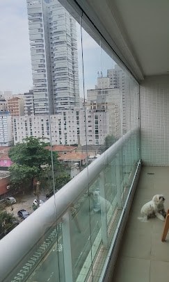 Sacada envidraçada com vista para os prédios da cidade