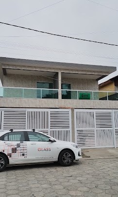 Guarda-corpo de vidro verde na fachada de um sobrado